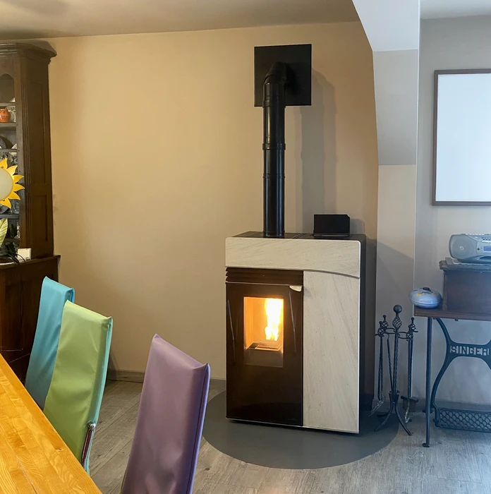 Intérieur résidentiel moderne avec poêle à bois contemporain en fonctionnement, cheminée design blanc et noir, conduit d'évacuation apparent