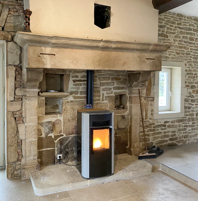 Intérieur résidentiel avec poêle à bois en fonctionnement, flammes visibles à travers la vitre