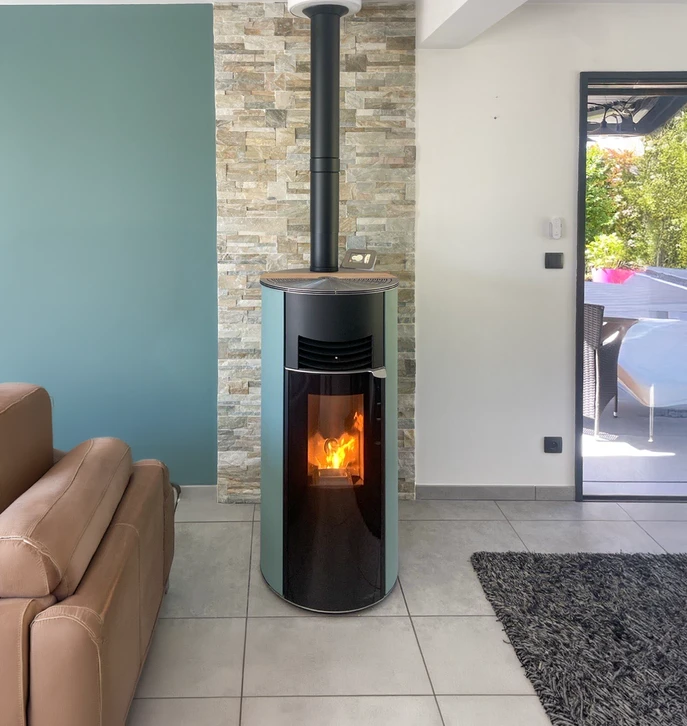 Intérieur résidentiel moderne avec poêle à granulés cylindrique beige et noir en fonctionnement, flammes visibles par la vitre