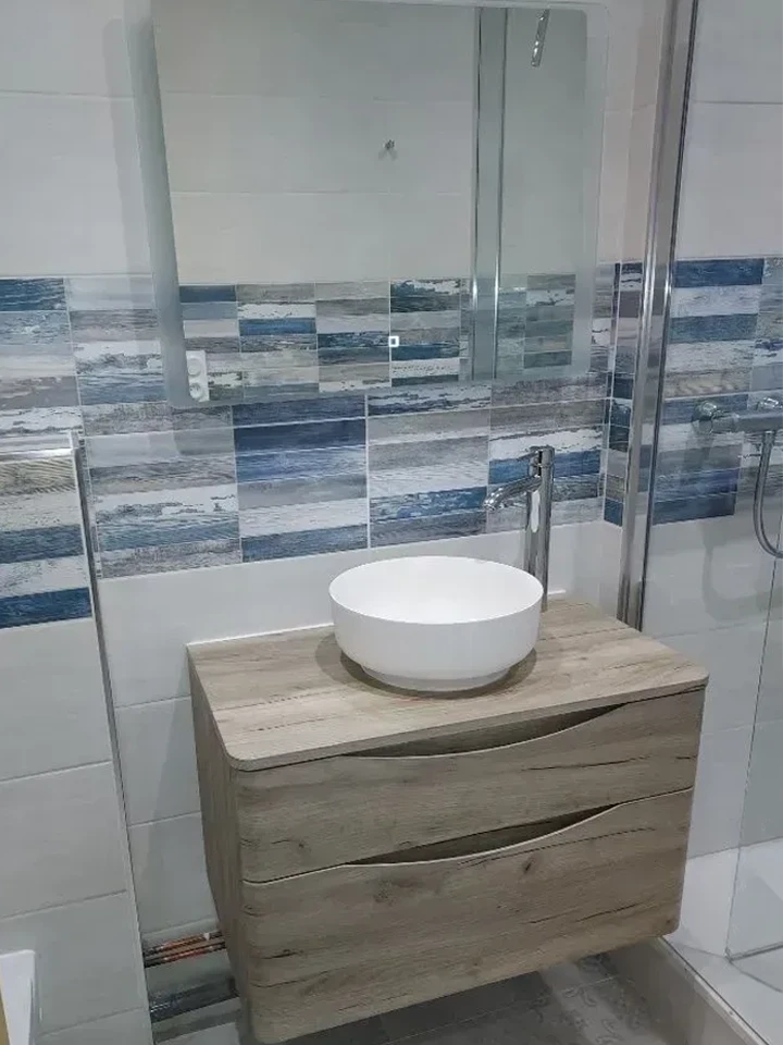 Salle de bain moderne avec baignoire blanche et mur gris