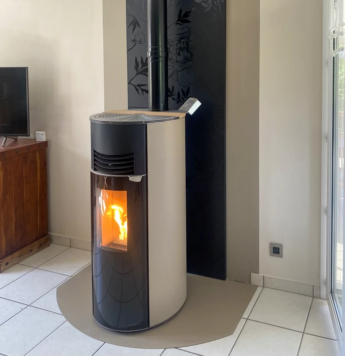 Intérieur moderne avec poêle à bois cylindrique noir en fonctionnement, flammes visibles