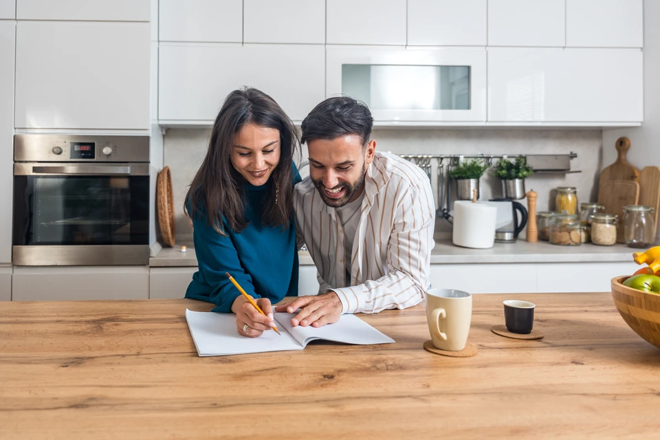 Plombier professionnel en uniforme travaillant dans une salle de bain moderne blanche