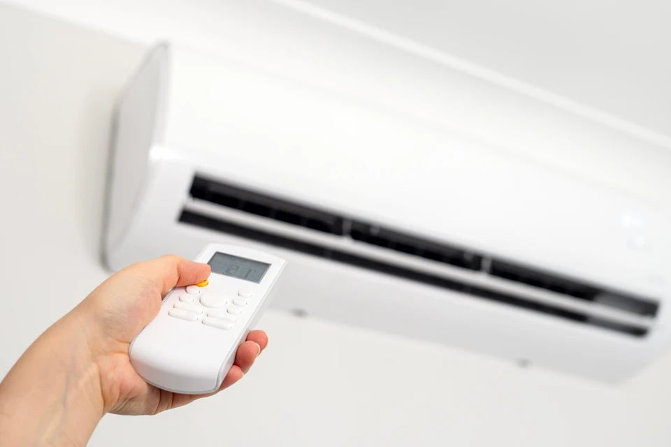 Intérieur moderne minimaliste avec fauteuil en cuir noir et coussin rouge, lampadaire articulé chrome, table basse noire avec vase rouge et tasse