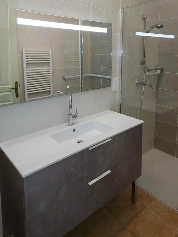Salle de bain moderne avec personne prenant un bain relaxant, pieds visibles dans baignoire blanche