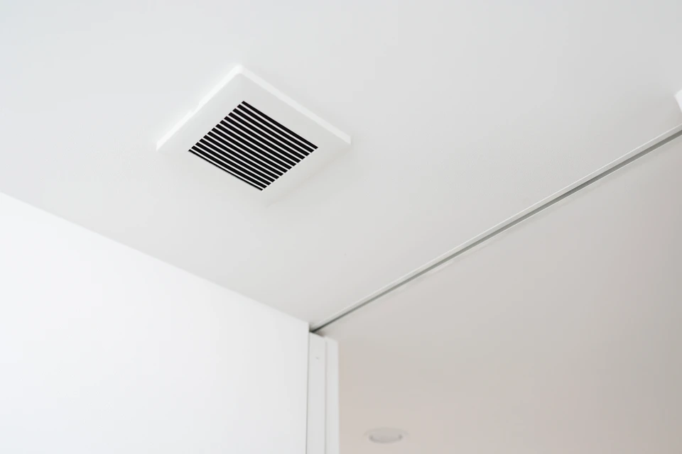 Ingénieur en bâtiment consultant des plans techniques dans un local technique avec système de ventilation industrielle