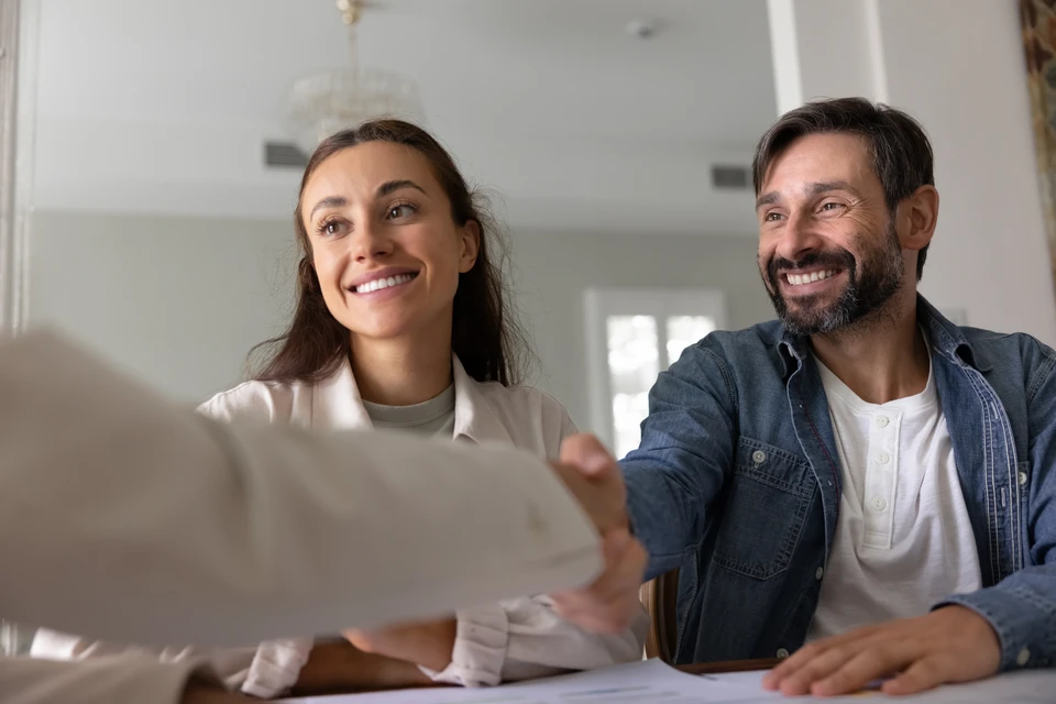 Scène d'intérieur moderne avec trois personnes assises autour d'une table basse dans un salon contemporain