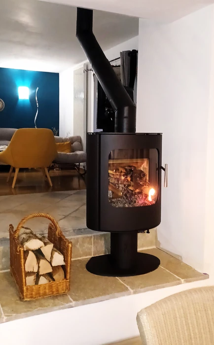 Intérieur chaleureux avec poêle à bois en fonctionnement dans alcôve en briques rouges