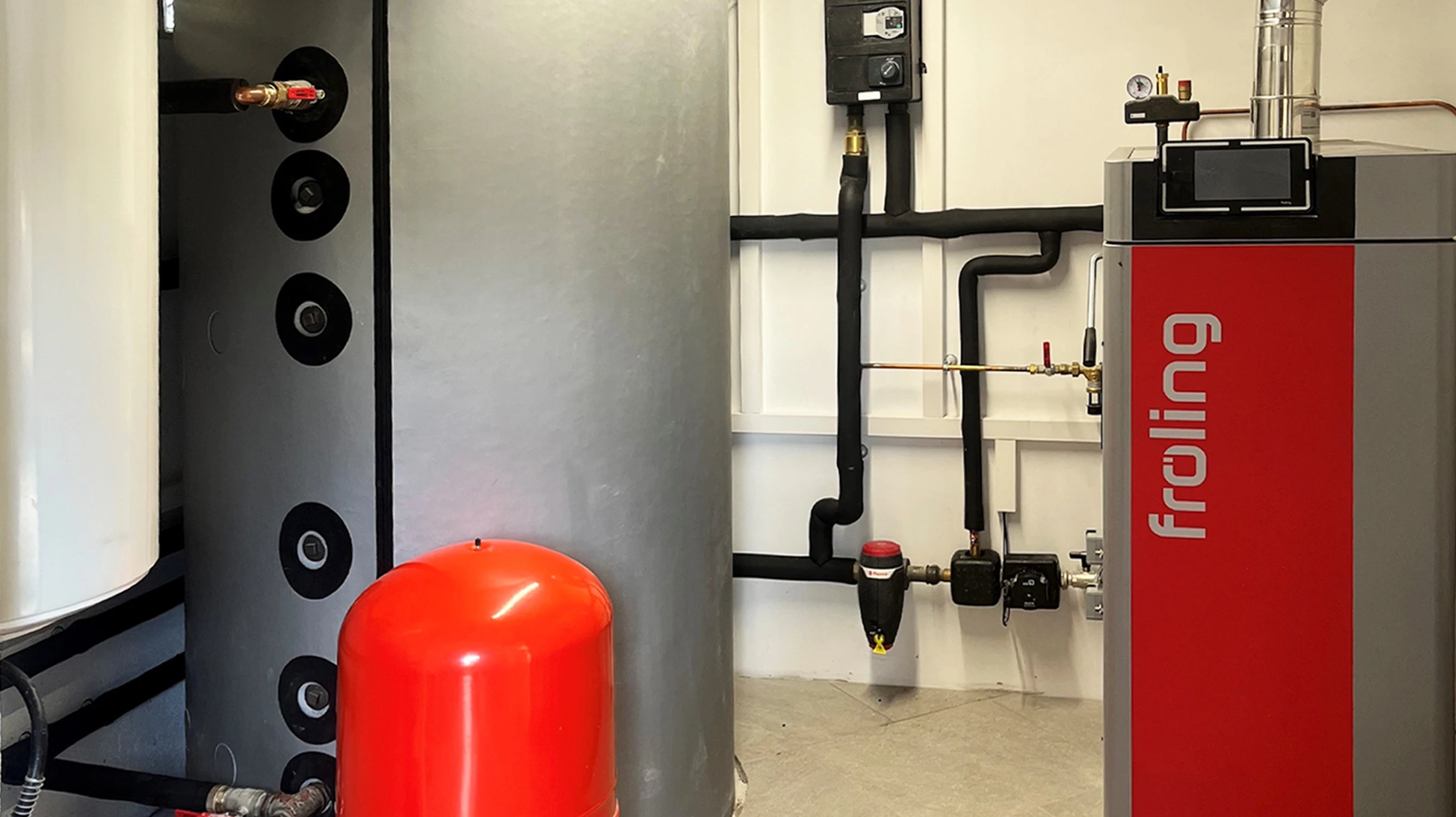 Salon moderne avec po&ecirc;le &agrave; bois cylindrique en m&eacute;tal gris install&eacute; sur socle circulaire